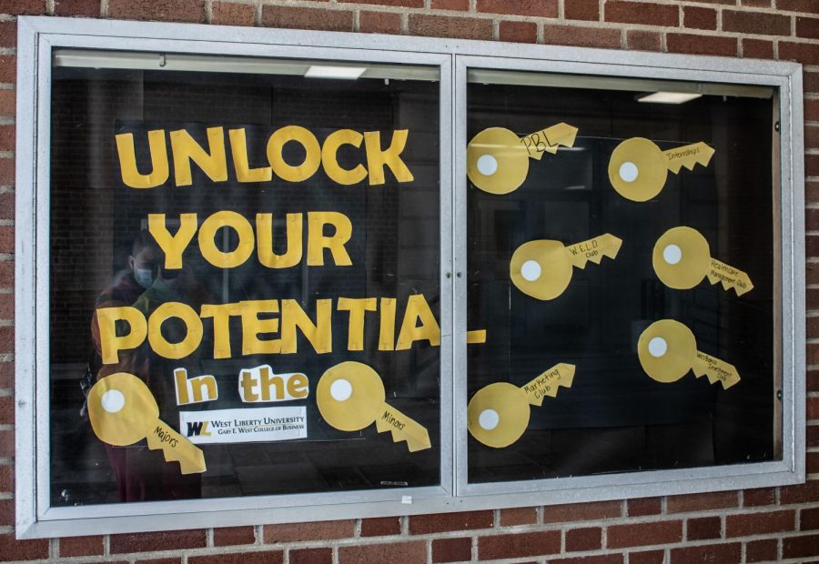 A College of Business motivational poster located on the outside of Main Hall.