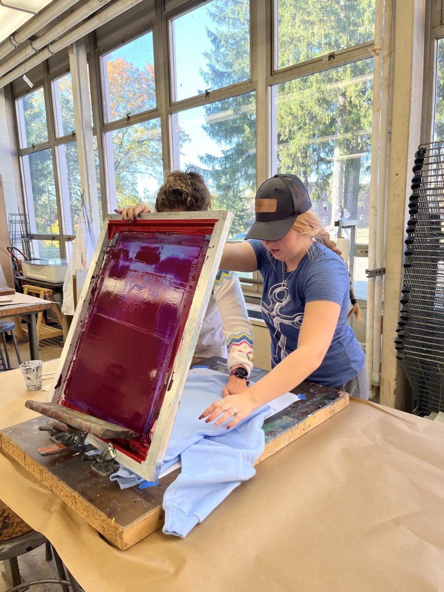 Aza Oneal operating a screen printing machine